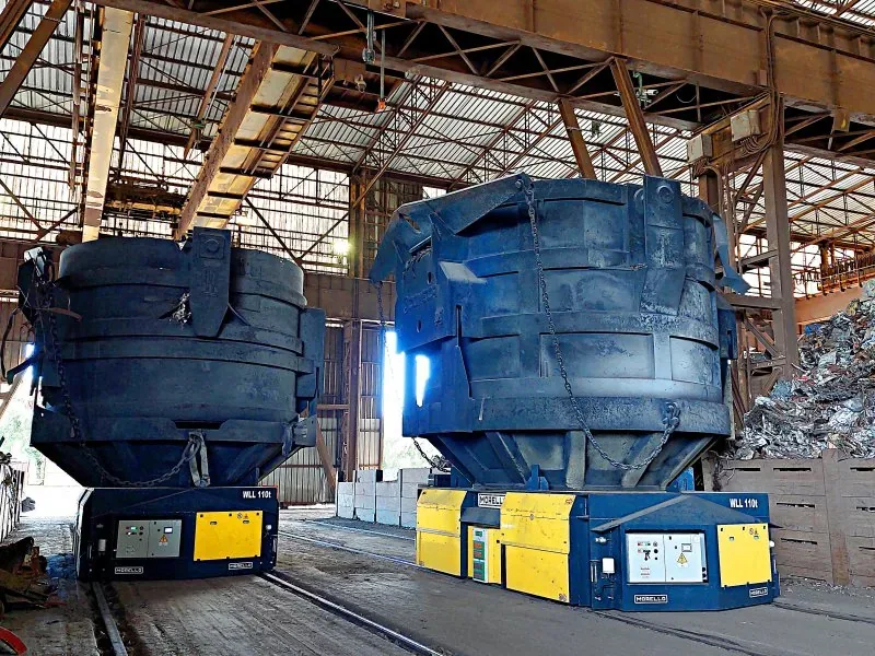 Two Morello 110 t battery-powered rail carts carrying steel scrap buckets in a melt shop
