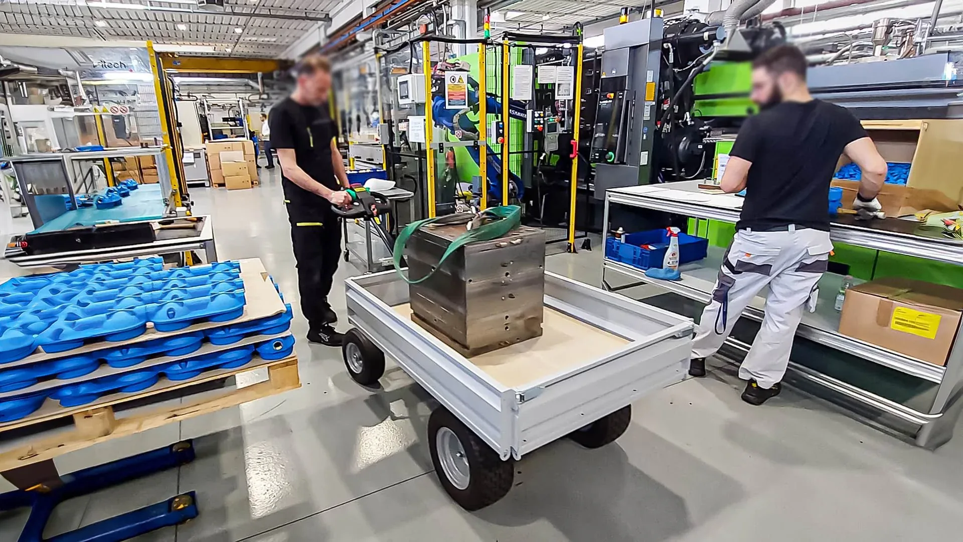 Operators moving a heavy mold on a Zallys JESPI electric platform truck
