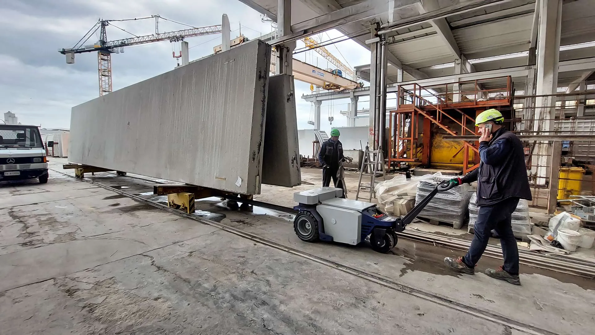 Zallys M10 electric tug pulling a heavy trolley with concrete slabs on rails