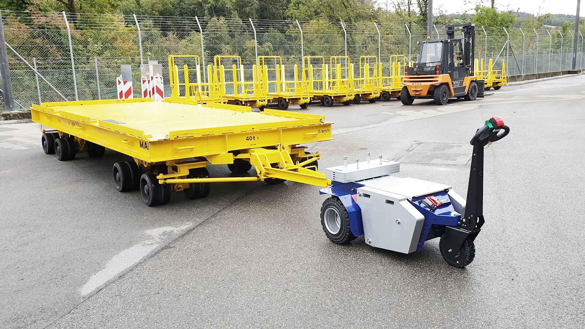 Zallys M10 electric tugger towing a heavy trolley in an industrial yard